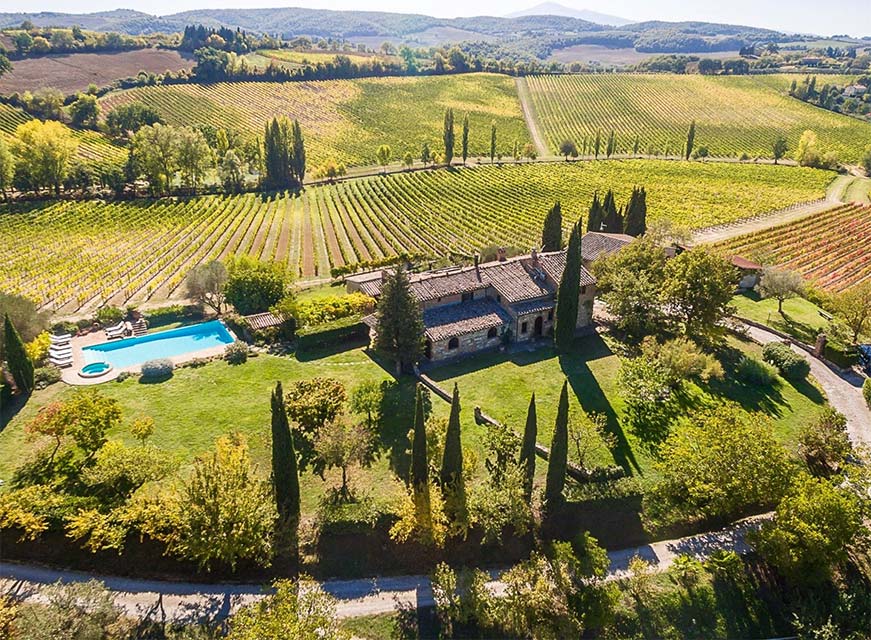 Farm in Tuscany Italy in the sunshine with fields to be harvested